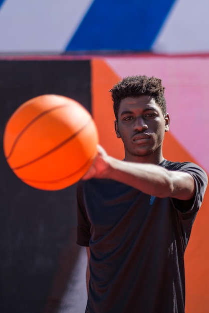 Joven con estilo de pelo afro jugando con el baloncesto