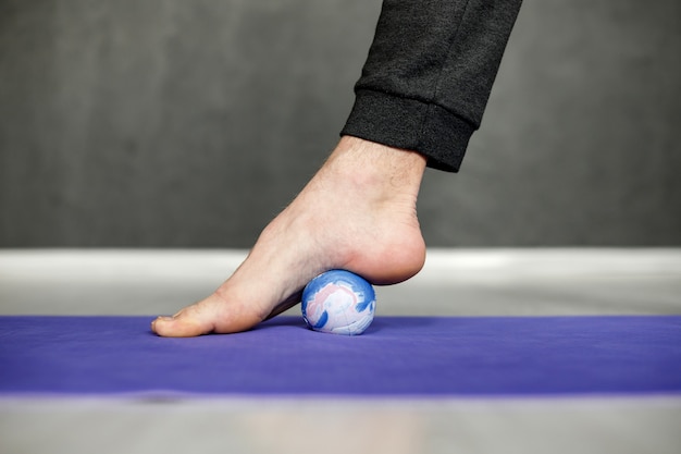 Foto joven está estirando en el gimnasio