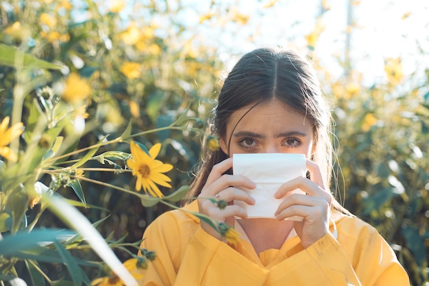 La joven va a estornudar, la niña sufre de alergia al polen durante la floración y usa servilleta