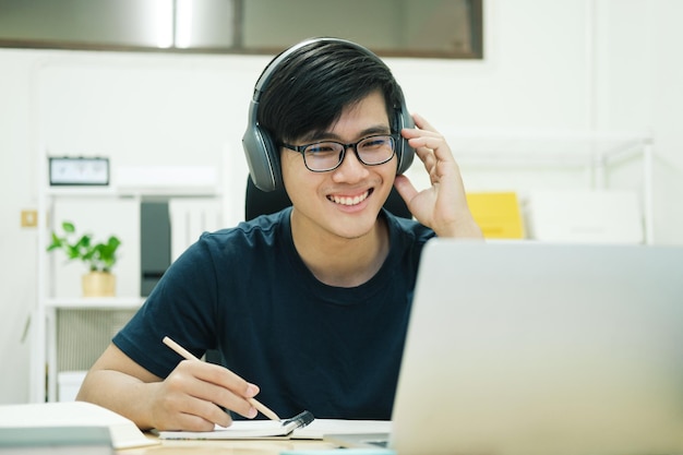 Joven estudia frente a la computadora portátil en casa