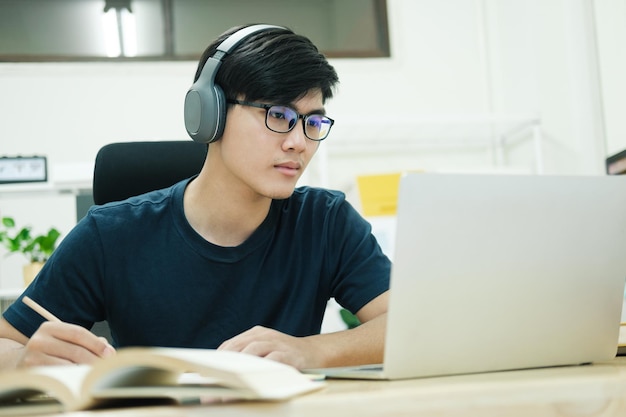 Joven estudia frente a la computadora portátil en casa