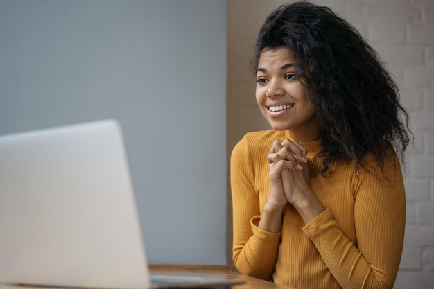 Joven estudiante afroamericano emocional que usa una computadora portátil esperando los resultados del examen