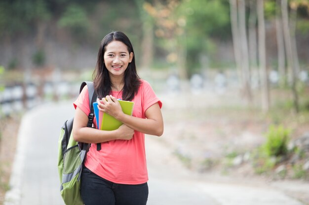 Joven estudiante asiática al aire libre, posando linda a la cámara