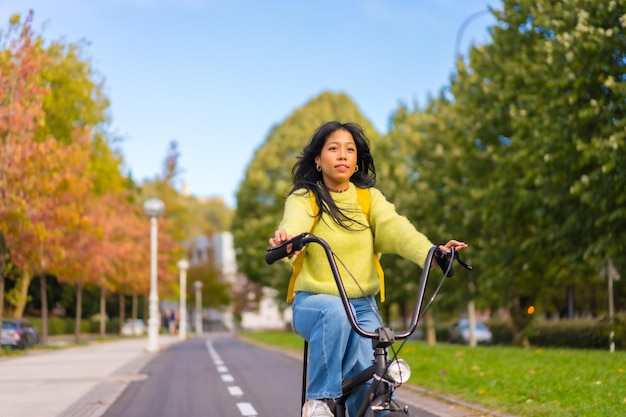 Joven estudiante asiática en bicicleta camino al campus universitario vida saludable ecológica