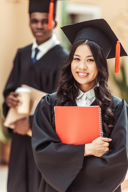 joven estudiante asiática feliz en disfraz de graduación