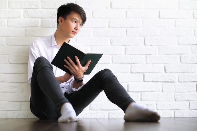 joven estudiante asiático con libros en las manos