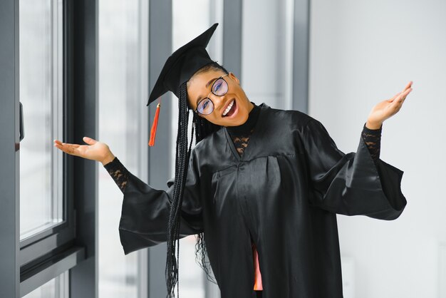 Joven estudiante en bata celebrando su graduación