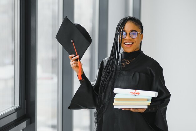 Joven estudiante en bata celebrando su graduación