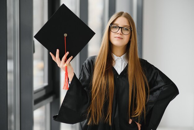 Joven estudiante en bata celebrando su graduación