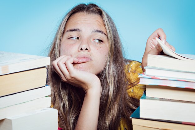 joven estudiante bonita abrumada con libros