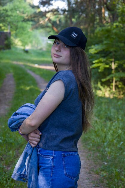 Joven estudiante con carpeta de ojos azules y mochila en el fondo de la naturaleza