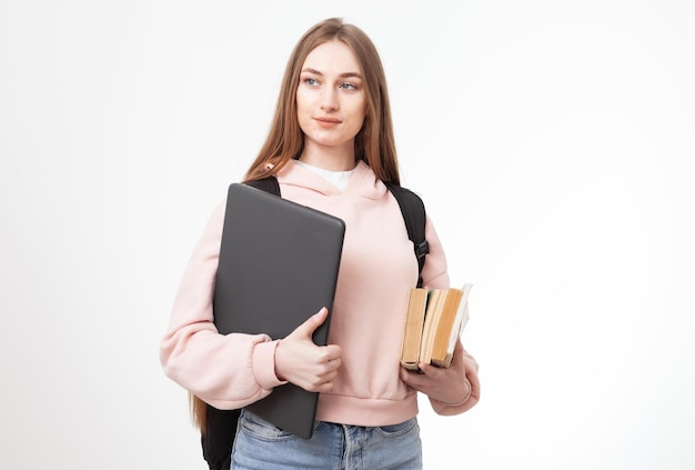 Joven estudiante caucásica atractiva con mochila portátil y libros aislados en fondo blanco