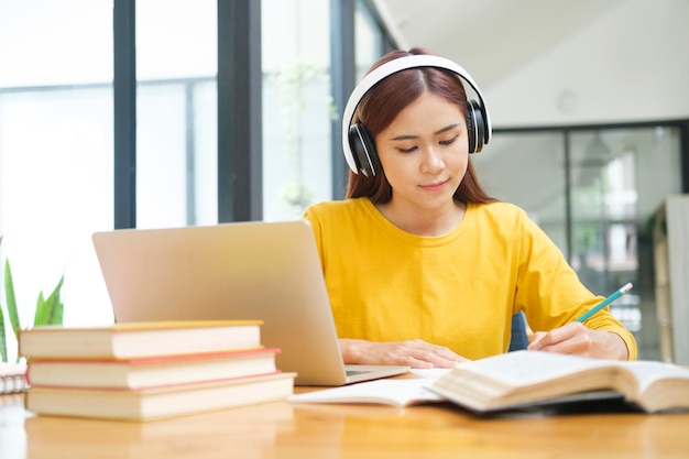 Joven estudiante de colegios usando computadora y dispositivo móvil estudiando en línea