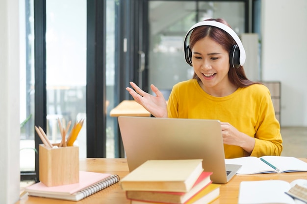 Joven estudiante de colegios usando computadora y dispositivo móvil estudiando en línea