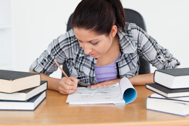 Joven estudiante escribiendo en su libro de ejercicios