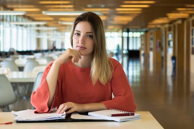 Joven estudiante estudiando en la biblioteca.