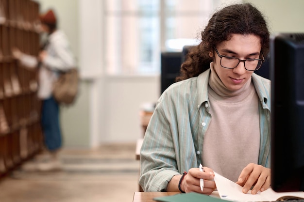 Joven estudiante estudiando en la biblioteca