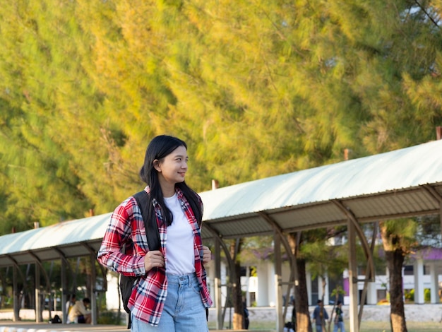 Una joven estudiante feliz caminando por la escuela con una mochila.