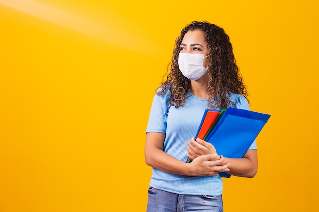 Joven estudiante graduado o de secundaria con mascarilla quirúrgica contra el covid 19. Nuevo concepto de normalidad y educación