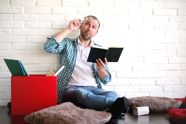 Joven estudiante en la habitación leyendo el periódico fuera de la caja.