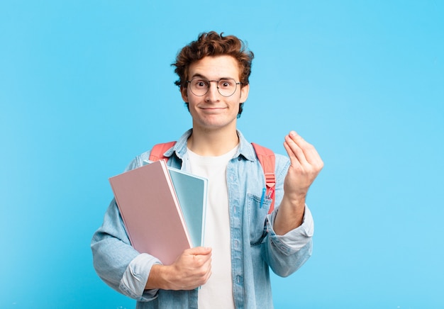 ¡Joven estudiante haciendo gesto de capice o dinero, diciéndole que pague sus deudas!