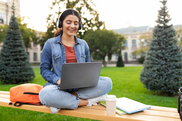 Una joven estudiante india tiene una lección en línea usando una computadora portátil