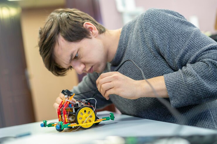 Foto joven estudiante de ingeniería trabaja en el proyecto de robot b