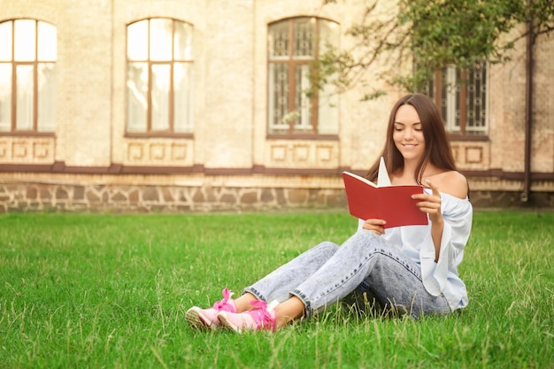 Joven estudiante leyendo en el parque