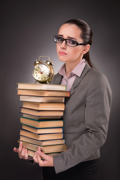 Joven estudiante con libros y reloj.