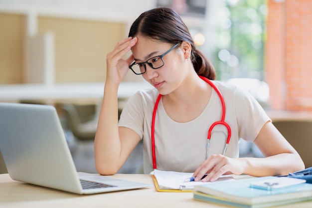 El joven estudiante de medicina se preocupa por el estrés del caso clínico del paciente, consulta la educación del estudio en la escuela de medicina