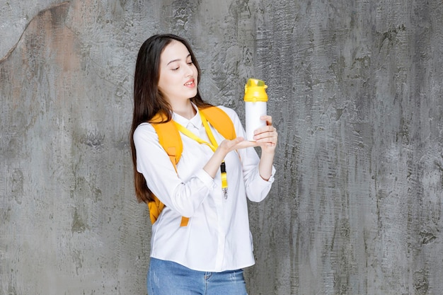 Joven estudiante en mochila con botella de agua. foto de alta calidad