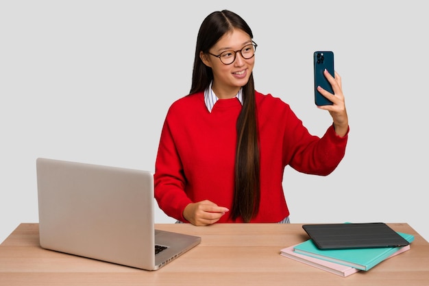 Joven estudiante mujer asiática en un lugar de trabajo con una computadora portátil aislada