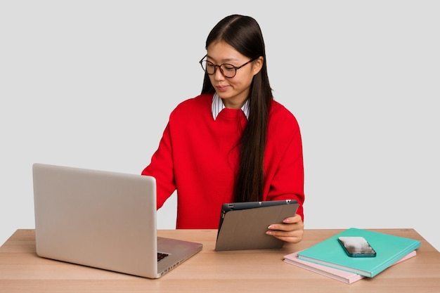 Joven estudiante mujer asiática en un lugar de trabajo con una computadora portátil aislada