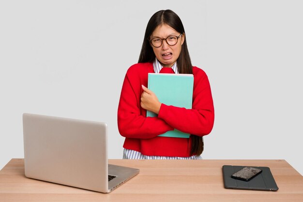 Joven estudiante mujer asiática en un lugar de trabajo con una computadora portátil aislada