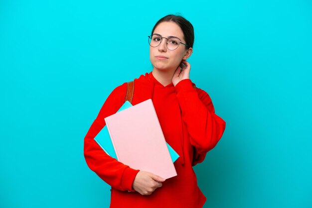 Joven estudiante mujer caucásica aislada de fondo azul que tiene dudas