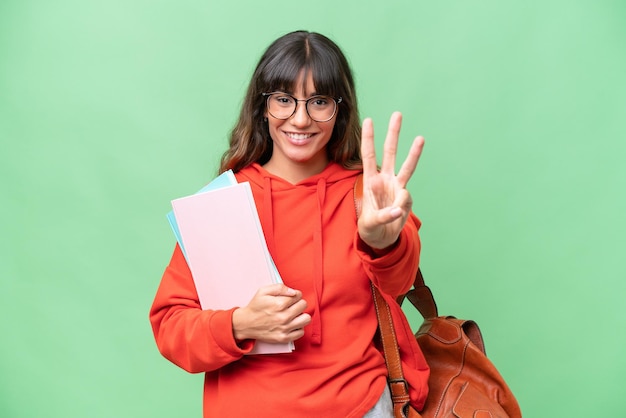 Joven estudiante mujer caucásica sobre fondo aislado feliz y contando tres con los dedos