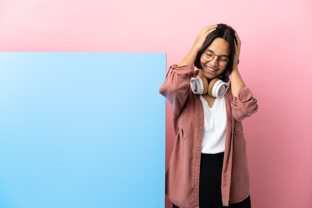 Joven estudiante mujer de raza mixta con una gran pancarta sobre fondo aislado riendo