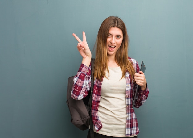 Joven estudiante mujer rusa haciendo un gesto de victoria