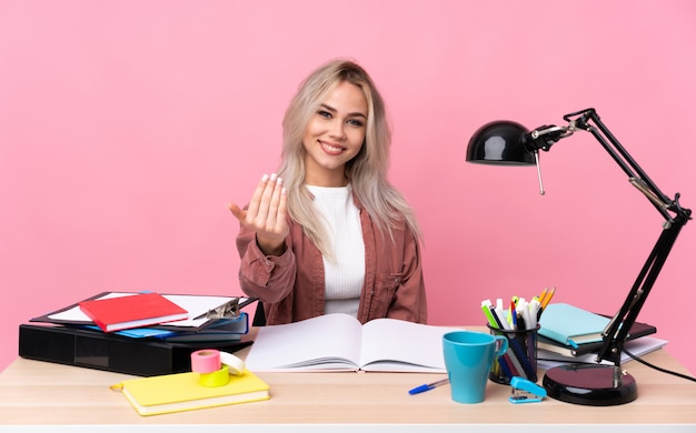 Joven estudiante mujer trabajando en una mesa invitando a venir