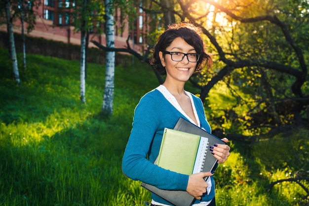 Joven estudiante con notebook. En línea estudiando al aire libre.