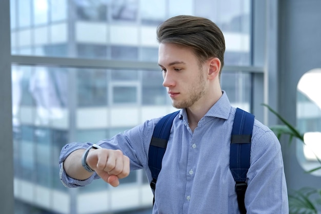 Foto un joven estudiante o un oficinista con camisa mirando sus relojes de pulsera y apresurándose a comprobar el tiempo