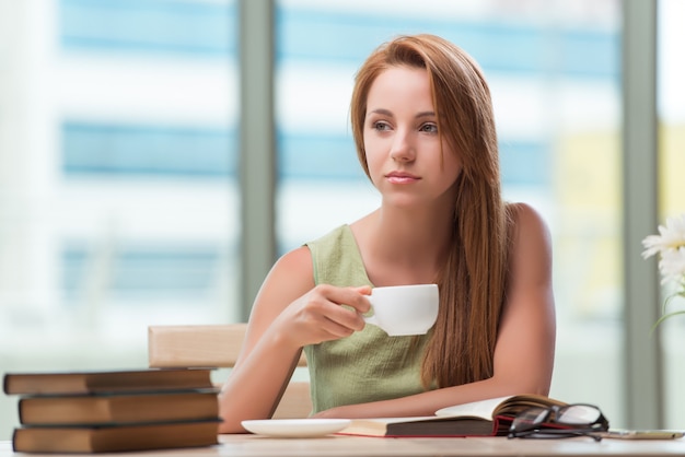 Joven estudiante preparándose para exámenes tomando té