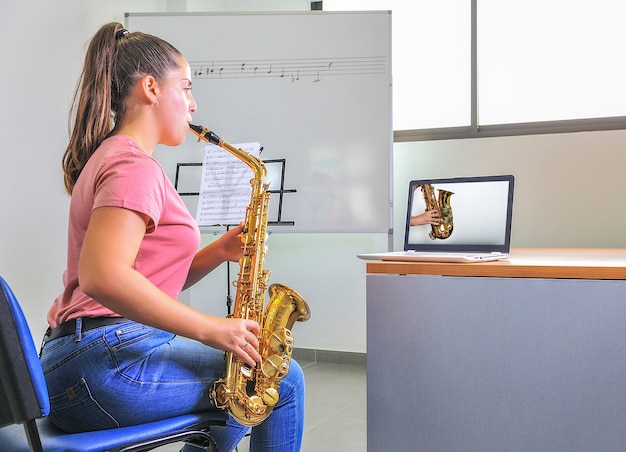 Joven estudiante que estudia la lección en línea en la computadora portátil.