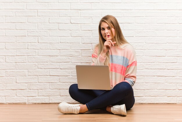 Joven estudiante rusa mujer sentada guardando un secreto o pidiendo silencio