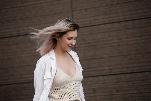 Foto una joven estudiante talentosa vestida con ropa informal camina por la ciudad atractiva mujer rubia disfrutando de su tiempo libre al aire libre en las calles de la ciudad