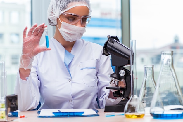 Joven estudiante trabajando con soluciones químicas en laboratorio.