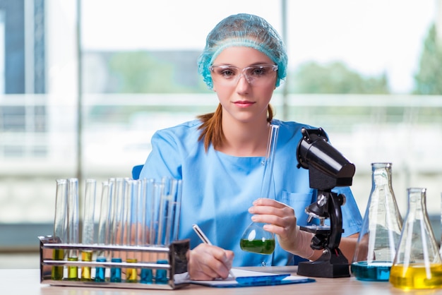 Joven estudiante trabajando con soluciones químicas en laboratorio.