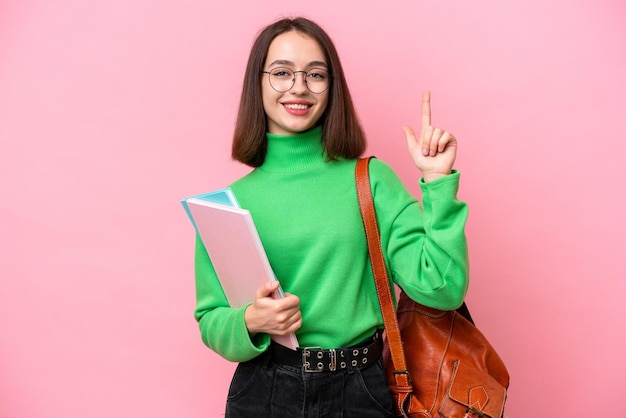 Joven estudiante ucraniana aislada de fondo rosa señalando una gran idea