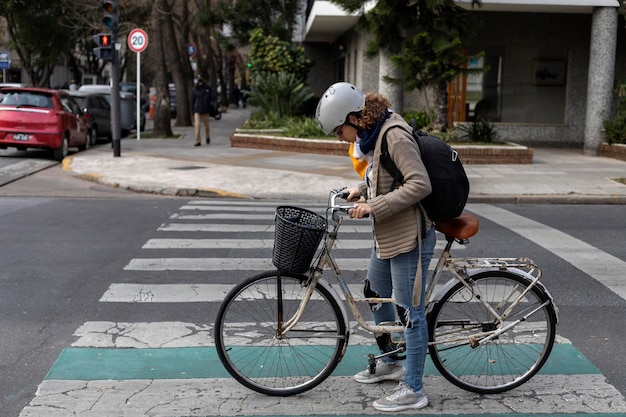 Una joven estudiante universitaria latinoamericana monta su bicicleta antigua por la ciudad