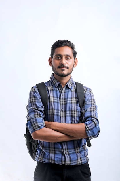 Foto joven estudiante universitario indio con paquete de bolsa sobre fondo blanco.
